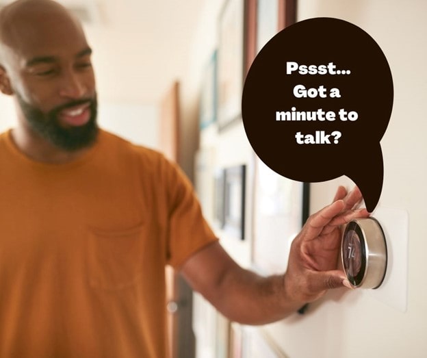 Man changing a thermostat that asks the man if they could talk.
