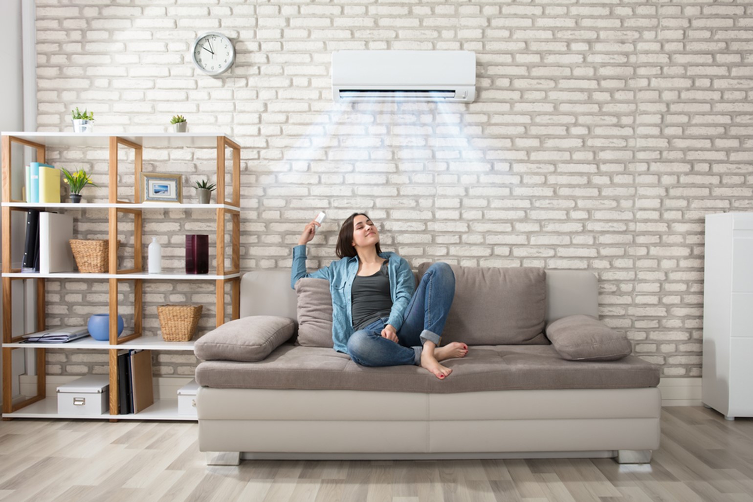 Woman sitting on couch under a mini-split ductless unit