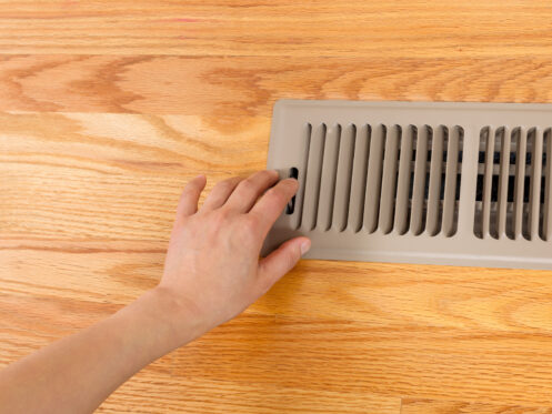 Person adjusting the heating vent