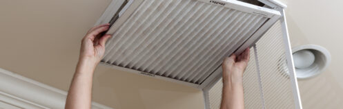 Reaching up to change filter in intake vent on ceiling